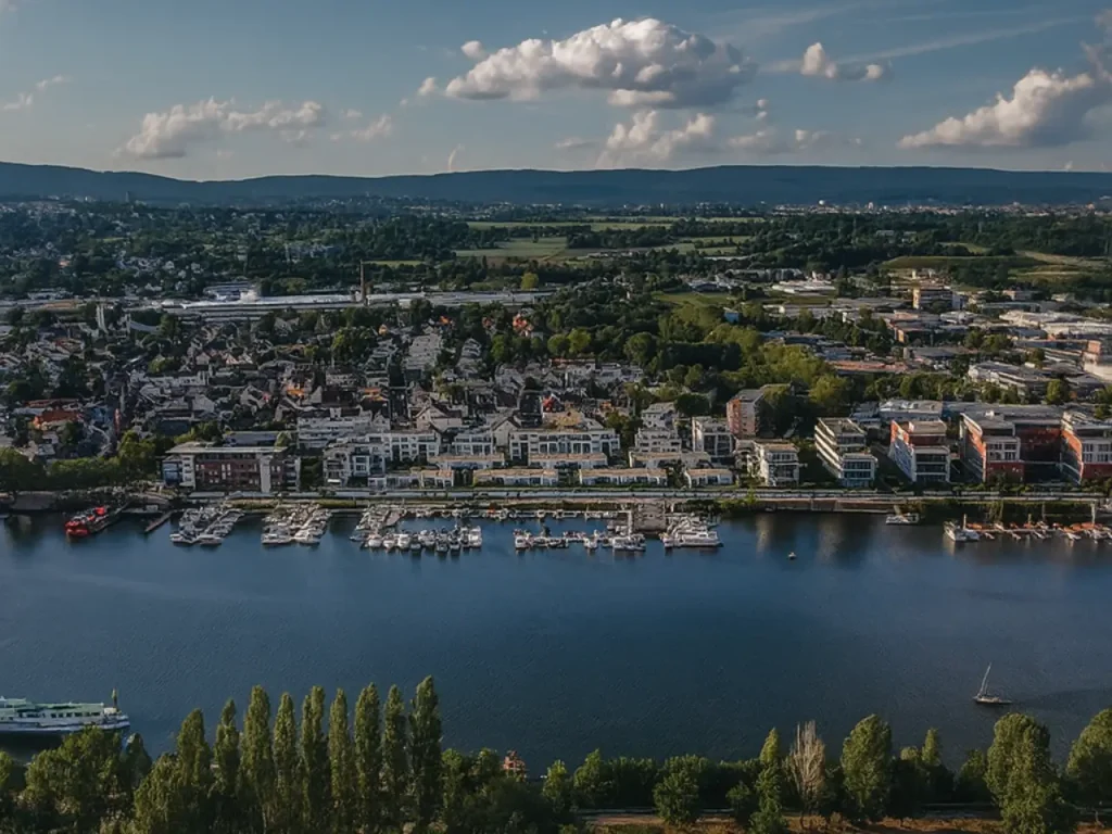 Panoramablick auf den Schiersteiner Hafen und das grüne Umland von Wiesbaden mit Bootsanlegern – regionale Umgebung für ein Fertighaus Wiesbaden.