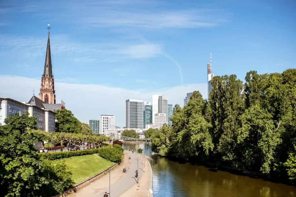 Skyline von Frankfurt mit Main, grünen Uferanlagen und Kirche, passend zum Thema Fertighaus Frankfurt