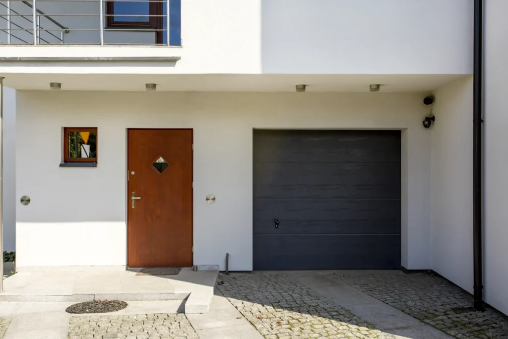 Schlichte weiße Haustür mit dekorativen Pflanzen nach professionellem Einbau durch BAUTENT