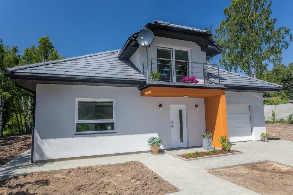 Weißes Gebäude mit grüner Haustür nach einer Fassadensanierung, die das Erscheinungsbild aufwertet