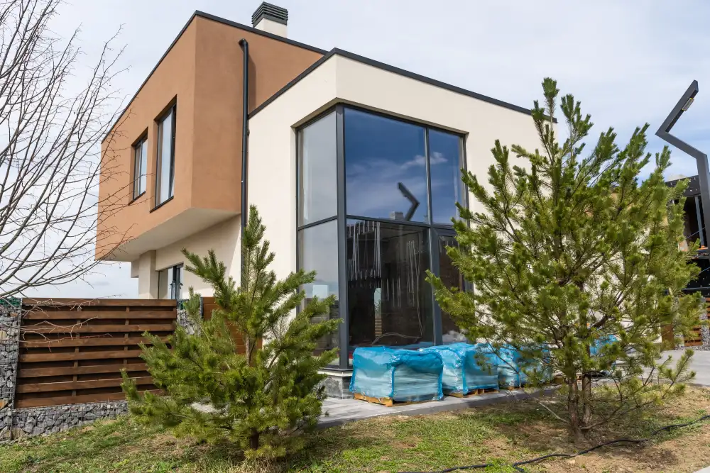 Moderne Architektur eines Hauses mit großen Fensterfronten, die einen Blick auf den Garten bieten – Beispiel für den Trend, Fenster zu erneuern und zu modernisieren.