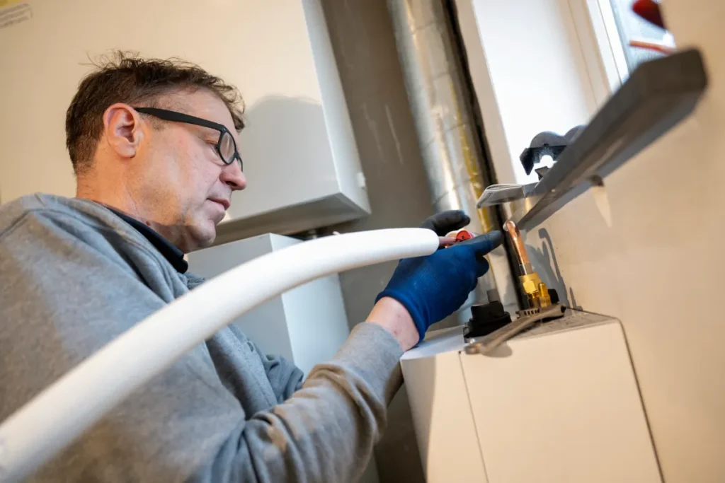 Fachmann bei der Installation einer Heizungsanlage, Teil einer Heizungssanierung